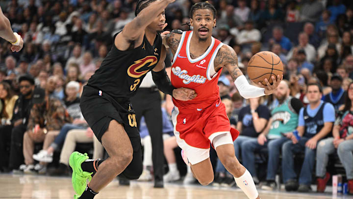 Mar 14, 2025; Memphis, Tennessee, USA; Memphis Grizzlies point guard Ja Morant (12) drives past his defender Cleveland Cavaliers small forward Isaac Okoro (35) in the 2nd quarter of the Cleveland Cavaliers vs. Memphis Grizzlies game at FedExForum. Mandatory Credit: Matthew Smith-Imagn Images