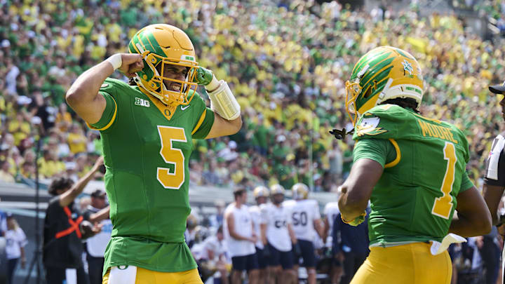 Oregon Ducks quarterback Dante Moore (5) celebrates with wide receiver Dakorien Moore (1)