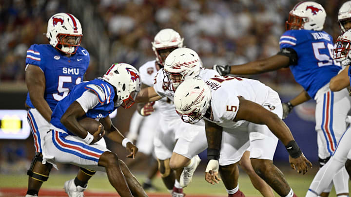 Sep 28, 2024; Dallas, Texas, USA; Florida State Seminoles defensive lineman Joshua Farmer (5) and linebacker Blake Nichelson (20) attempts to tackle Southern Methodist Mustangs quarterback Kevin Jennings (7) during the first quarter at Gerald J. Ford Stadium. Mandatory Credit: Jerome Miron-Imagn Images