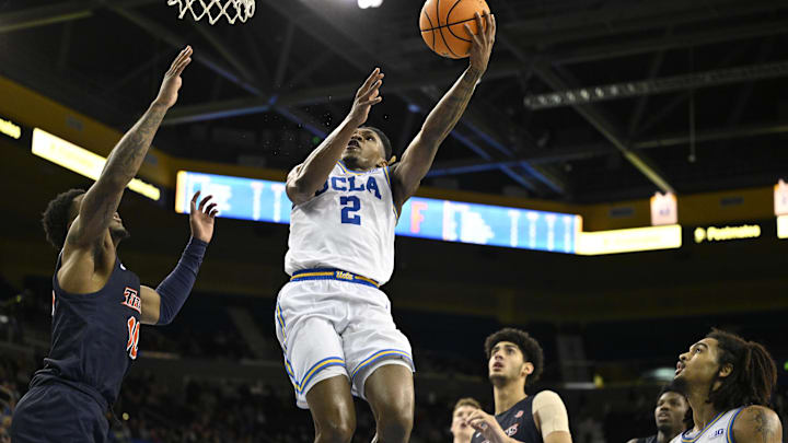 Nov 22, 2024; Los Angeles, California, USA; UCLA Bruins guard Dylan Andrews (2) drives to the basket past Cal State Fullerton Titans guard Antwan Robinson (10) and forward Kendrick De Luna (24) during the second half at Pauley Pavilion presented by Wescom. Mandatory Credit: Robert Hanashiro-Imagn Images