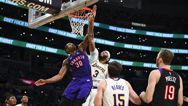 Nov 10, 2024; Los Angeles, California, USA; Toronto Raptors guard Ochai Agbaji (30) attempts to block Los Angeles Lakers forward Anthony Davis (3) during the first half at Crypto.com Arena. Mandatory Credit: Jonathan Hui-Imagn Images