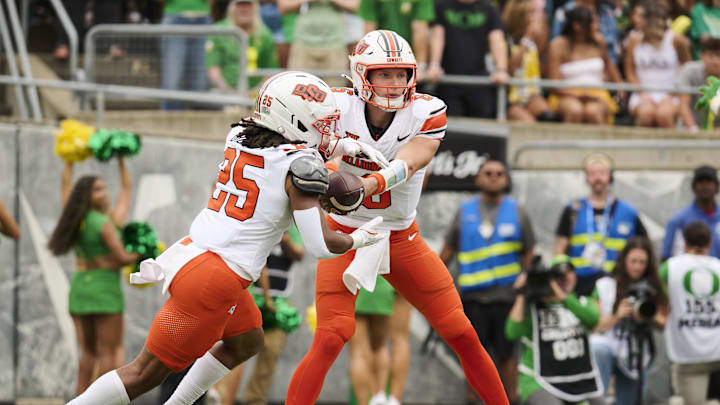 Sep 6, 2025; Eugene, Oregon, USA; Oklahoma State Cowboys quarterback Zane Flores (6) hands the ball to running back Freddie Brock IV (25) during the first half against the Oregon Ducks at Autzen Stadium. Mandatory Credit: Troy Wayrynen-Imagn Images