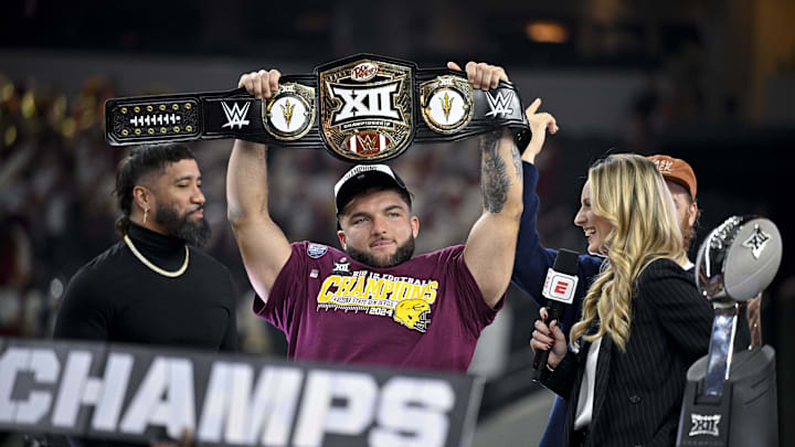 Dec 7, 2024; Arlington, TX, USA; Arizona State Sun Devils running back Cam Skattebo (4) holds up the WWE Big 12 championship belt after the Sun Devils defeat the Iowa State Cyclones and win the 2024 Big 12 Championship at AT&T Stadium. Mandatory Credit: Jerome Miron-Imagn Images