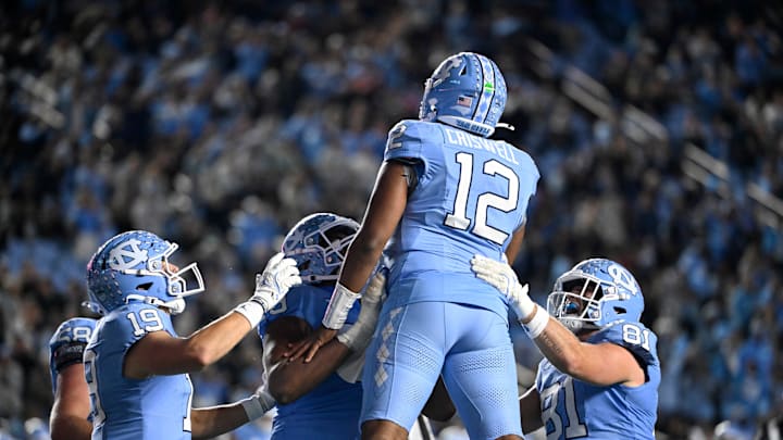 Nov 16, 2024; Chapel Hill, North Carolina, USA; North Carolina Tar Heels quarterback Jacolby Criswell (12) is lifted up by offensive lineman Howard Sampson (79) after scoring a touchdown as tight ends Jake Johnson (19) and John Copenhaver (81) celebrate in the second quarter at Kenan Memorial Stadium. Nov 16, 2024; Chapel Hill, North Carolina, USA; North Carolina Tar Heels quarterback Jacolby Criswell (12) is lifted up by offensive lineman Howard Sampson (79) after scoring a touchdown as tight ends Jake Johnson (19) and John Copenhaver (81) celebrate in the second quarter at Kenan Memorial Stadium.
