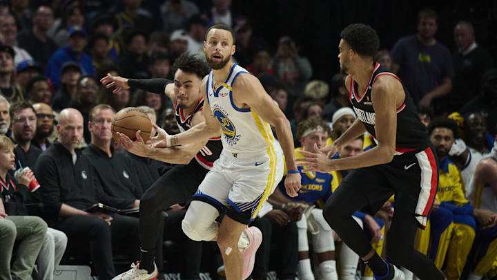 Apr 11, 2025; Portland, Oregon, USA; Portland Trail Blazers forward Justin Minaya (10) breaks up a pass attempt by Golden State Warriors guard Stephen Curry (30) at Moda Center. Mandatory Credit: Troy Wayrynen-Imagn Images