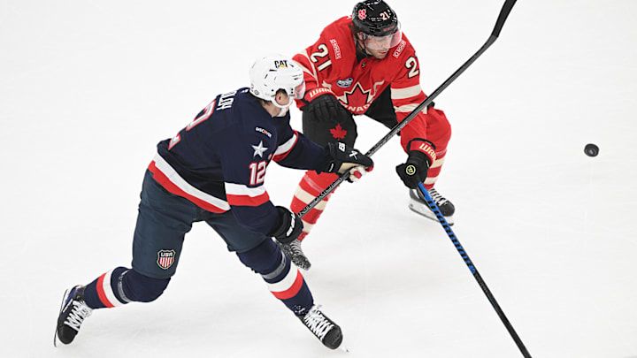 Feb 20, 2025; Boston, MA, USA; [Imagn Images direct customers only]  Team USA forward Matt Boldy (12) battles for the puck against Team Canada forward Brayden Point (21) during the first period during the 4 Nations Face-Off ice hockey championship game at TD Garden. Mandatory Credit: Brian Fluharty-Imagn Images