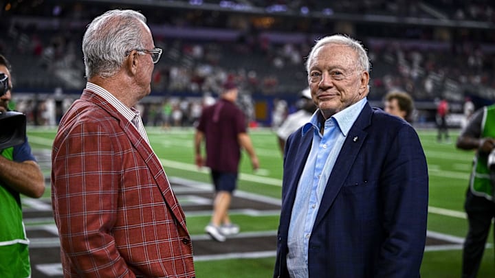 Dallas Cowboys owner Jerry Jones and EVP Stephen Jones present the winner's trophy after a game between Texas A&M and Arkansas at AT&T Stadium. 