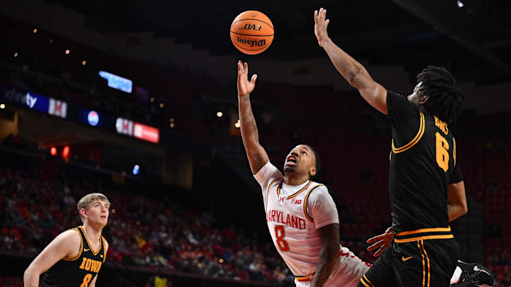 Feb 11, 2026; College Park, Maryland, USA;  Maryland Terrapins guard David Coit (8) attempts a lay up around Iowa Hawkeyes guard Tavion Banks (#6) in the second half at Xfinity Center. Mandatory Credit: Jamie Sabau-Imagn Images