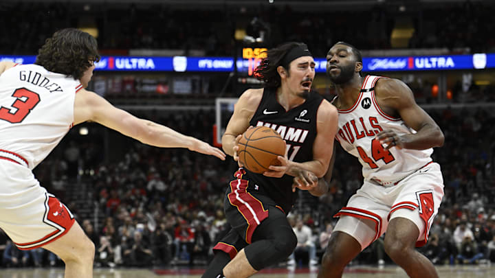 Feb 4, 2025; Chicago, Illinois, USA;  Miami Heat guard Jaime Jaquez Jr. (11) drives between Chicago Bulls guard Josh Giddey (3) and  forward Patrick Williams (44) during the second half at United Center. Mandatory Credit: Matt Marton-Imagn Images