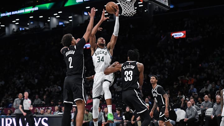 Dec 8, 2024; Brooklyn, New York, USA; Milwaukee Bucks forward Giannis Antetokounmpo (34) drives to the basket while being defended by Brooklyn Nets forward Cameron Johnson (2) and Brooklyn Nets center Nic Claxton (33) during the second half at Barclays Center. Mandatory Credit: John Jones-Imagn Images