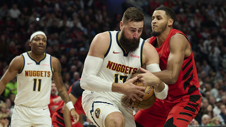 Oct 31, 2025; Portland, Oregon, USA; Portland Trail Blazers forward Kris Murray (24) ties up Denver Nuggets center Jonas Valanciunas (17) during the second half at Moda Center. Mandatory Credit: Troy Wayrynen-Imagn Images