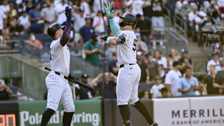 Jun 20, 2024; Bronx, New York, USA; New York Yankees outfielder Aaron Judge (99) high fives designated hitter Giancarlo Stanton (27) after hitting a two-run home run against the Baltimore Orioles during the third inning at Yankee Stadium. Mandatory Credit: John Jones-USA TODAY Sports