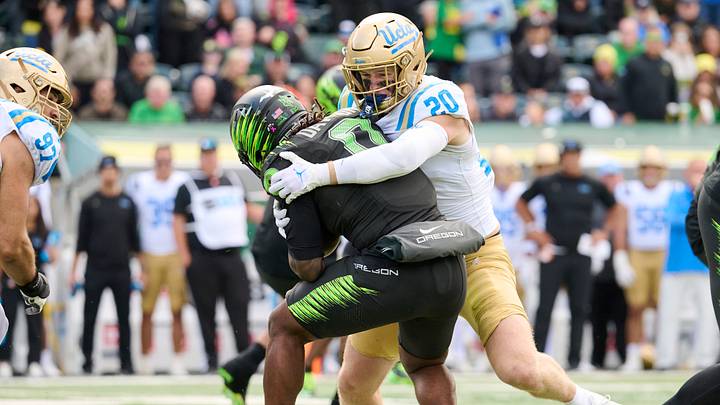 Oct 10, 2026; Eugene, Oregon, USA; UCLA Bruins linebacker Scott Taylor (20) tackles Oregon Ducks running back Jordon Davison (0) during the second half at Autzen Stadium. Mandatory Credit: Troy Wayrynen-Imagn Images