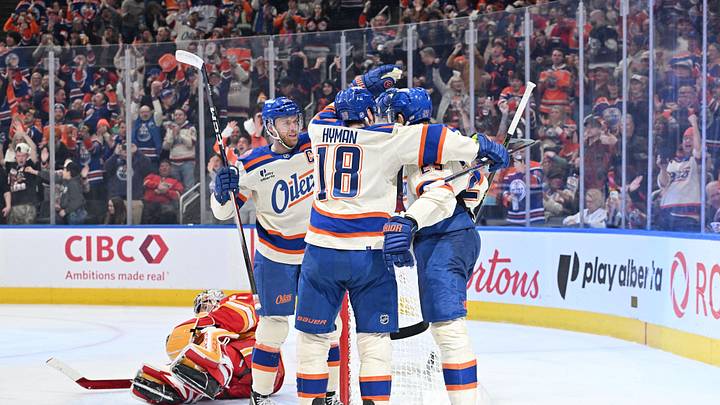 Dec 23, 2025; Edmonton, Alberta, CAN; Oilers center Connor McDavid (97), center Leon Draisaitl (29), and left winger Zach Hyman (18) celebrate a goal on Calgary Flames goalie Dustin Wolf (32) during the third period at Rogers Place. Mandatory Credit: Walter Tychnowicz-Imagn Images