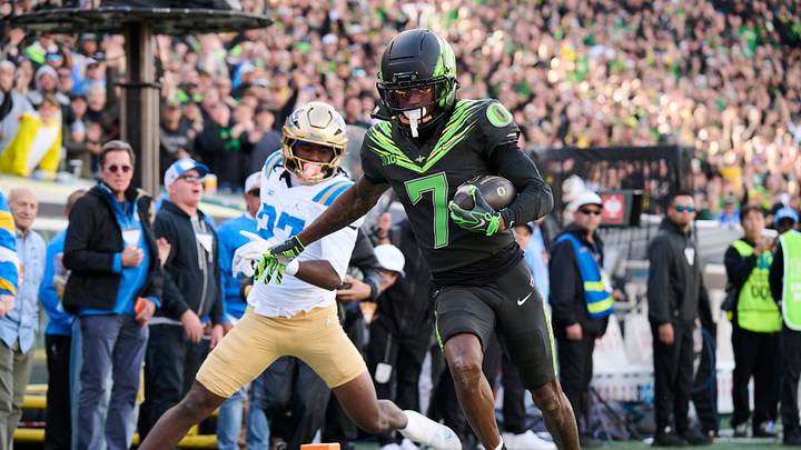 Oct 10, 2026; Eugene, Oregon, USA; Oregon Ducks wide receiver Evan Stewart (7) scores a touchdown during the second half against UCLA Bruins defensive back Ta'shawn James (27) at Autzen Stadium. Mandatory Credit: Troy Wayrynen-Imagn Images