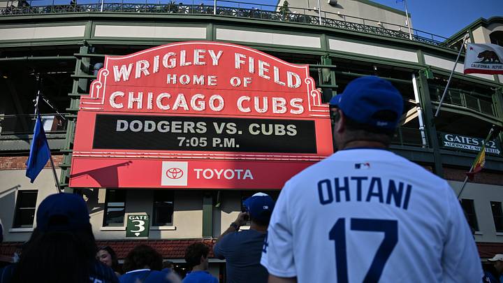 Aug 3, 2026; Chicago, Illinois, USA; A Los Angeles Dodgers fan sporting a Los Angeles Dodgers designated hitter Shohei Ohtani (not pictured) jersey looks on as the marquee is seen prior to a game against the Chicago Cubs at Wrigley Field. Mandatory Credit: Patrick Gorski-Imagn Images