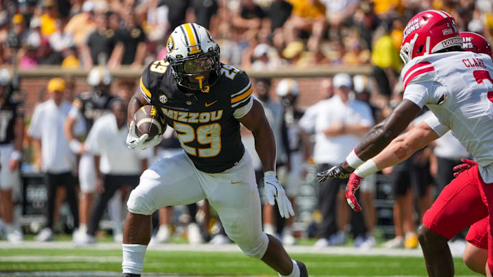 Sep 13, 2025; Columbia, Missouri, USA; Missouri Tigers running back Ahmad Hardy (29) runs the ball as Louisiana-Lafayette Ragin Cajuns safety Jalen Clark (2) defends during the first half of the game at Faurot Field at Memorial Stadium. Mandatory Credit: Denny Medley-Imagn Images