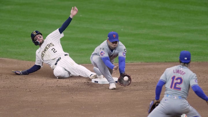 Milwaukee Brewers' Brice Turang (2) beats a throw to New York Mets second baseman Jose Iglesias (11) by shortstop Francisco Lindor (12) during the third inning of their wild-card playoff game against the New York Mets Wednesday, October 2, 2024 at American Family Field in Milwaukee, Wisconsin.