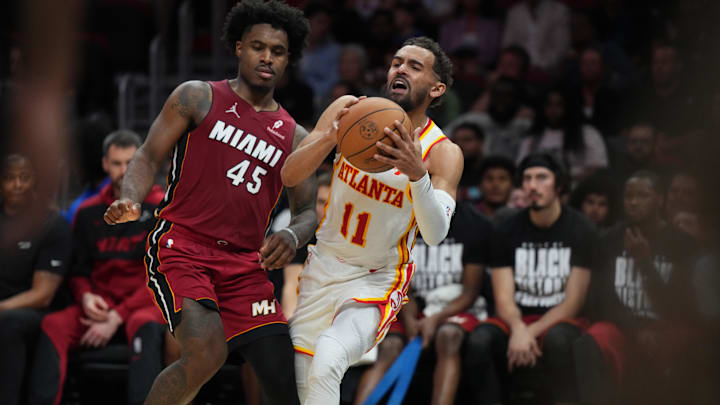 Feb 26, 2025; Miami, Florida, USA;  Atlanta Hawks guard Trae Young (11) grabs the ball before it goes out of bounds as Miami Heat guard Davion Mitchell (45) defends in the second half at Kaseya Center. Mandatory Credit: Jim Rassol-Imagn Images