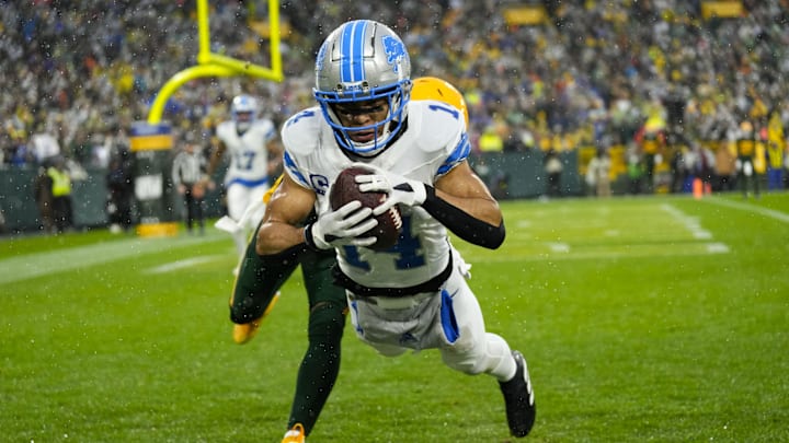 Nov 3, 2024; Green Bay, Wisconsin, USA;  Detroit Lions wide receiver Amon-Ra St. Brown (14) catches a pass in front of Green Bay Packers cornerback Keisean Nixon (25) to score a touchdown during the second quarter at Lambeau Field. Mandatory Credit: Jeff Hanisch-Imagn Images