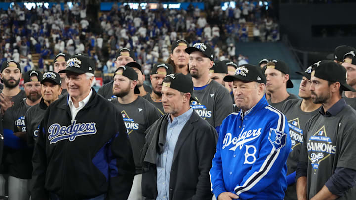 Oct 17, 2025; Los Angeles, California, USA; Los Angeles Dodgers owner Mark Walter, president of baseball operations Andrew Friedman and president Stan Kasten react after game four of the NLCS round for the 2025 MLB playoffs against the Milwaukee Brewers at Dodger Stadium. Mandatory Credit: Kirby Lee-Imagn Images