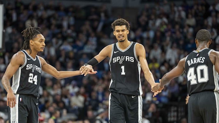 Dec 29, 2024; Minneapolis, Minnesota, USA; San Antonio Spurs center Victor Wembanyama (1) celebrates with San Antonio Spurs guard Devin Vassell (24) and San Antonio Spurs forward Harrison Barnes (40) after making a shot against the Minnesota Timberwolves in the second half at Target Center. Mandatory Credit: Jesse Johnson-Imagn Images