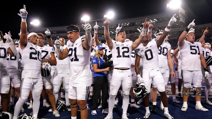 BYU celebrates a win over SMU with fans in the crowd.