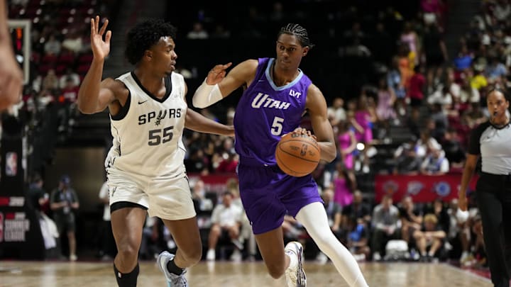 Jul 14, 2025; Las Vegas, NV, USA;  Utah Jazz forward Cody Williams (5) drives the ball against San Antonio Spurs guard Harrison Ingram (55) during the first half of a NBA basketball game at the Thomas & Mack Center. Mandatory Credit: Lucas Peltier-Imagn Images