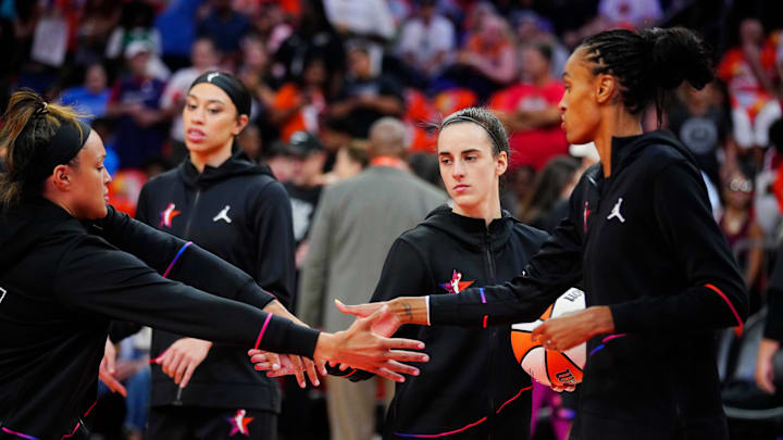 Team WNBA player Caitlin Clark high fives teammates Kayla McBride and DeWanna Bonner during the WNBA All-Star Game at Footprint Center in Phoenix on July 20, 2024.