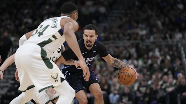 Mar 8, 2025; Milwaukee, Wisconsin, USA; Orlando Magic guard Cole Anthony (50) drives against Milwaukee Bucks guard AJ Green (20) and forward Giannis Antetokounmpo (34) in the second half at Fiserv Forum. Mandatory Credit: Michael McLoone-Imagn Images