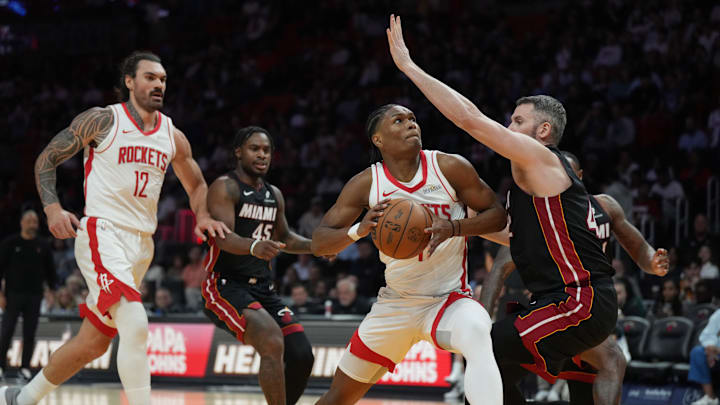 Mar 21, 2025; Miami, Florida, USA;  Houston Rockets forward Amen Thompson (1) drives to the basket as Miami Heat forward Kevin Love (42) defends at Kaseya Center. Mandatory Credit: Jim Rassol-Imagn Images