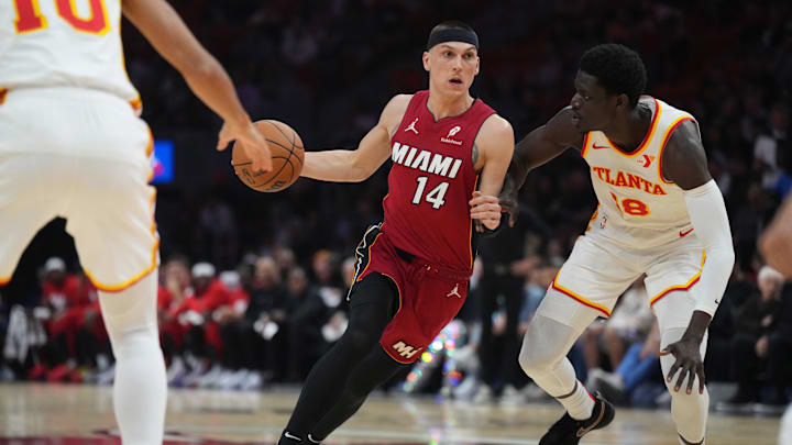 Feb 26, 2025; Miami, Florida, USA;  Miami Heat guard Tyler Herro (14) drives past Atlanta Hawks forward Mouhamed Gueye (18) in the first half at Kaseya Center. Mandatory Credit: Jim Rassol-Imagn Images