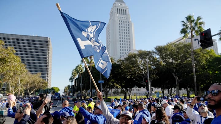 Nov 1, 2024; Los Angeles, CA, USA; A fan waves a flag to support the Los Angeles Dodgers before the 2024 World Series championship parade near Los Angeles City Hall. Mandatory Credit: Kirby Lee-Imagn Images