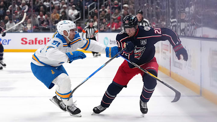 Blue Jackets center Isac Lundestrom battles with Blues defenseman Matthew Kessel. 