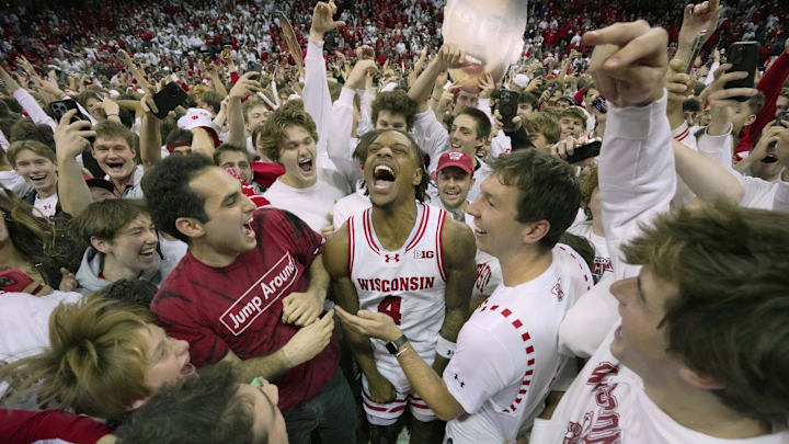 Nov 15, 2024; Madison, Wisconsin, USA;Wisconsin guard Kamari McGee (4) joins fans who stormed the court after their game Friday, November 15, 2024 at the Kohl Center in Madison, Wisconsin. Unranked Wisconsin upset Arizona 103-88. Mandatory Credit: Mark Hoffman/USA TODAY Network via Imagn Images 