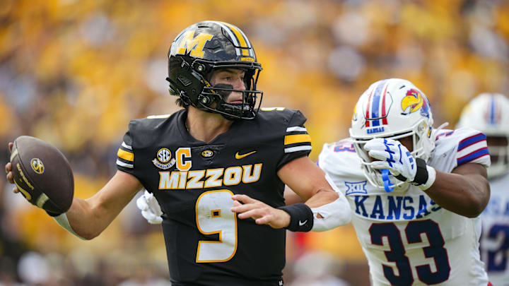 Sep 6, 2025; Columbia, Missouri, USA; Missouri Tigers quarterback Beau Pribula (9) rolls out to pass against Kansas Jayhawks defensive end Leroy Harris III (33) during the first half at Faurot Field at Memorial Stadium. Mandatory Credit: Jay Biggerstaff-Imagn Images
