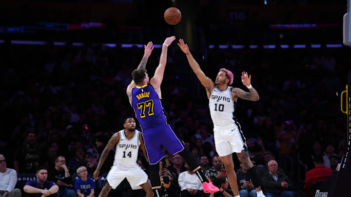Mar 17, 2025; Los Angeles, California, USA; Los Angeles Lakers guard Luka Doncic (77) shoots the ball against San Antonio Spurs forward Jeremy Sochan (10) in the first half at Crypto.com Arena. Mandatory Credit: Kirby Lee-Imagn Images