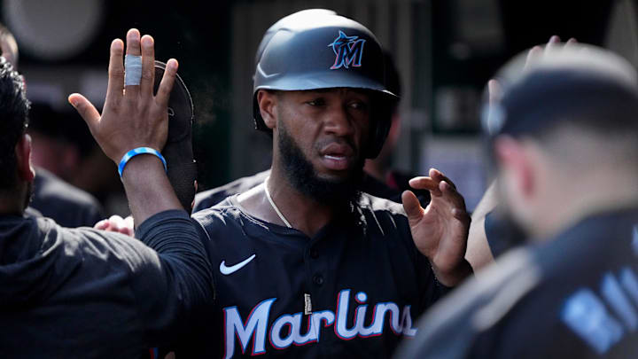 Miami Marlins left fielder Bryan De La Cruz (14) celebrates in the dugout after scoring on a Jake Burger single in the fourth inning of the MLB National League game between the Cincinnati Reds and the Miami Marlins at Great American Ball Park in downtown Cincinnati on Saturday, July 13, 2024. The Reds led 1-0 after two innings. The Reds won 10-6.
