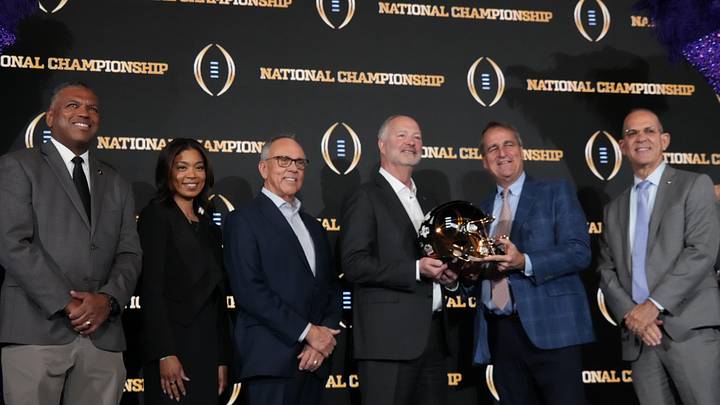 Jan 20, 2026; Miami, FL, USA; From left: College Football Playoff executive director Rich Clark, Las Vegas 2027 host committee members Sandra Douglass Morgan, Jim Gibson and Steve Hill and 2026 Miami host committee members Jack Seile and Eric Poms pose during the CFP host committee handoff press conference at Marriott Marquis Miami. Mandatory Credit: Kirby Lee-Imagn Images Jan 20, 2026; Miami, FL, USA; From left: College Football Playoff executive director Rich Clark, Las Vegas 2027 host committee members Sandra Douglass Morgan, Jim Gibson and Steve Hill and 2026 Miami host committee members Jack Seile and Eric Poms pose during the CFP host committee handoff press conference at Marriott Marquis Miami. Mandatory Credit: Kirby Lee-Imagn Images