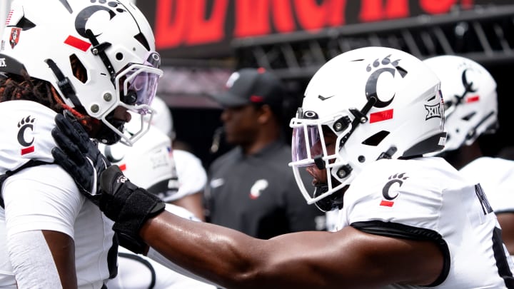 Cincinnati Bearcats defensive end Eric Phillips (97) hits Cincinnati Bearcats defensive lineman Marquaze Parker (98) while warming up before the College Football game between the Cincinnati Bearcats and the Towson Tigers at Nippert Stadium in Cincinnati on Saturday, Aug. 31, 2024.