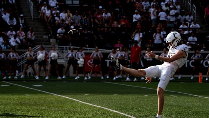 Cincinnati Bearcats punter Mason Fletcher (31) punts the ball in the fourth quarter of the College Football game between the Cincinnati Bearcats and the Towson Tigers at Nippert Stadium in Cincinnati on Saturday, Aug. 31, 2024.