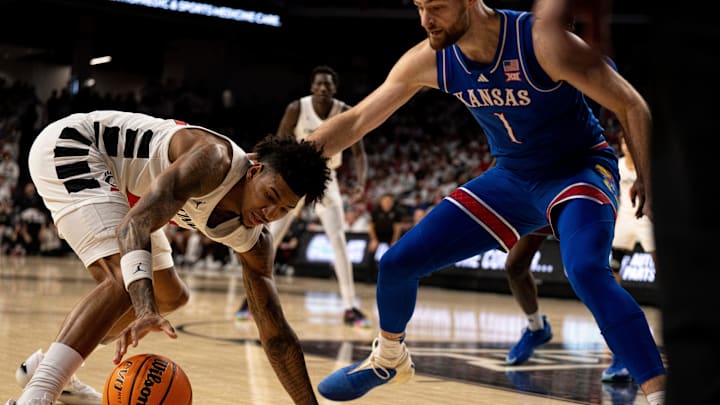 Cincinnati Bearcats forward Dillon Mitchell (23) grabs a loose ball as Kansas Jayhawks center Hunter Dickinson (1) guards him in the first half of the NCAA basketball game at Fifth Third Arena in Cincinnati on Saturday, January 11, 2025. Cincinnati Bearcats forward Dillon Mitchell (23) grabs a loose ball as Kansas Jayhawks center Hunter Dickinson (1) guards him in the first half of the NCAA basketball game at Fifth Third Arena in Cincinnati on Saturday, January 11, 2025.