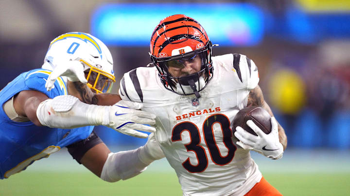 Nov 17, 2024; Inglewood, California, USA; Cincinnati Bengals running back Chase Brown (30) carries the ball against Los Angeles Chargers linebacker Daiyan Henley (0) in the second half at SoFi Stadium. Mandatory Credit: Kirby Lee-Imagn Images