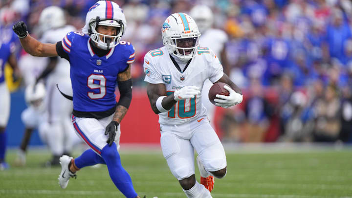 Nov 3, 2024; Orchard Park, New York, USA; Miami Dolphins wide receiver Tyreek Hill (10) runs with the ball against Buffalo Bills safety Taylor Rapp (9) during the second half at Highmark Stadium. 