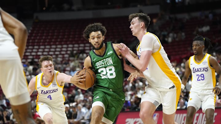 Jul 15, 2024; Las Vegas, NV, USA; Boston Celtics forward Anton Watson (28) drives the ball against Los Angeles Lakers center Colin Castleton (14) during the second half at Thomas & Mack Center. Mandatory Credit: Lucas Peltier-Imagn Images
