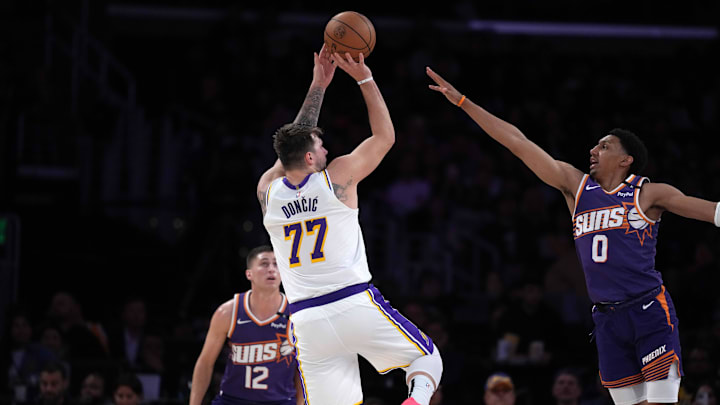 Mar 16, 2025; Los Angeles, California, USA; Los Angeles Lakers guard Luka Doncic (77) shoots the ball against Phoenix Suns forward Ryan Dunn (0) in the second half at Crypto.com Arena. Mandatory Credit: Kirby Lee-Imagn Images