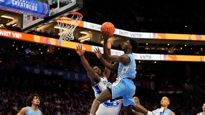 Mar 14, 2025; Charlotte, NC, USA; North Carolina Tar Heels guard Drake Powell (9) shoots as Duke Blue Devils guard Sion James (14) defends in the second half at Spectrum Center. Mandatory Credit: Bob Donnan-Imagn Images