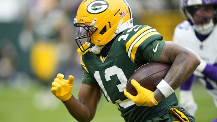 Nov 23, 2025; Green Bay, Wisconsin, USA; Green Bay Packers wide receiver Dontayvion Wicks (13) runs after the catch against the Minnesota Vikings during the first half at Lambeau Field. Mandatory Credit: Kayla Wolf-Imagn Images