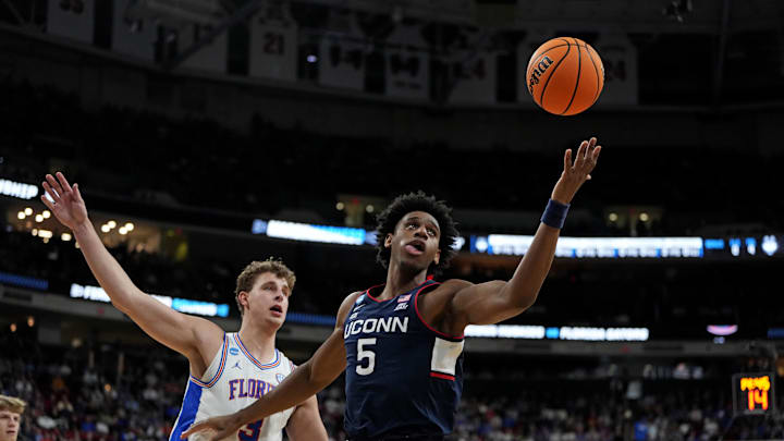 Mar 23, 2025; Raleigh, NC, USA; Connecticut Huskies center Tarris Reed Jr. (5) drives to the basket as Florida Gators center Micah Handlogten (3) defends during the first half in the second round of the NCAA Tournament at Lenovo Center. Mandatory Credit: Bob Donnan-Imagn Images
