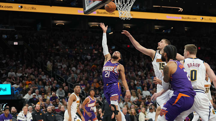 Feb 8, 2025; Phoenix, Arizona, USA; Phoenix Suns guard Tyus Jones (21) puts up a layup against the Denver Nuggets during the first half at Footprint Center. Mandatory Credit: Joe Camporeale-Imagn Images